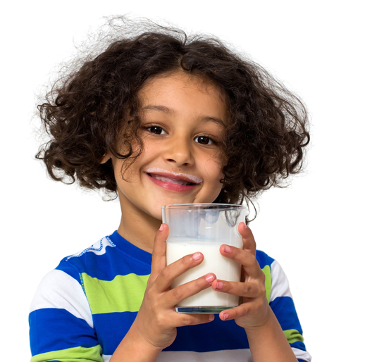 Glückliches Kind mit einem Glas Milch in der Hand.